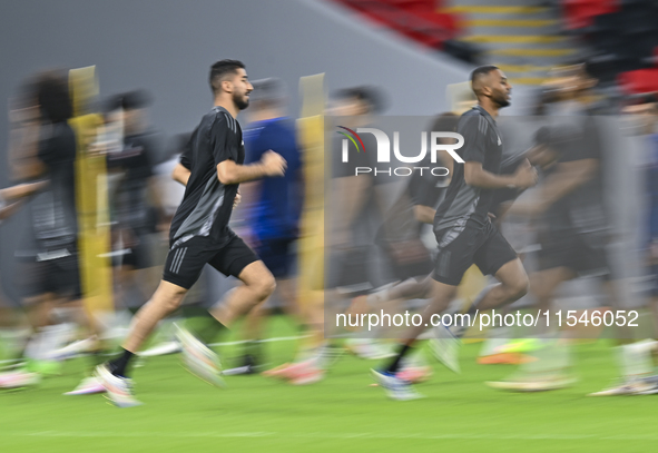 Mohammad Waad (L) and Abdulaziz Hatem (R) from the Qatar National football team attend a training session at Ahmad Bin Ali Stadium in Al Ray...