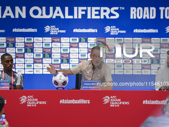 United Arab Emirates national team Head coach Paulo Bento (C) and player Khalifa Al Hammadi (L) attend a press conference at Ahmad Bin Ali S...