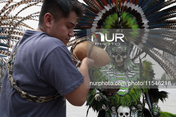 A pre-Hispanic dancer drinks pulque outside the Supreme Court of Justice of the Nation in Mexico City, Mexico, on September 4, 2024, where a...