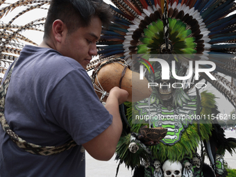 A pre-Hispanic dancer drinks pulque outside the Supreme Court of Justice of the Nation in Mexico City, Mexico, on September 4, 2024, where a...