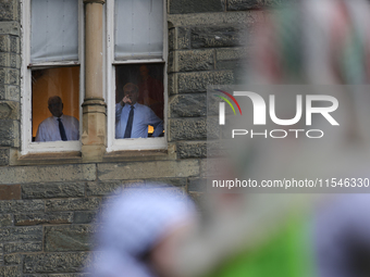 Faculty watch from windows as pro-Palestine demonstrators protest on the steps of Healy Hall at Georgetown University in Washington, D.C. on...