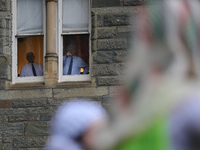 Faculty watch from windows as pro-Palestine demonstrators protest on the steps of Healy Hall at Georgetown University in Washington, D.C. on...