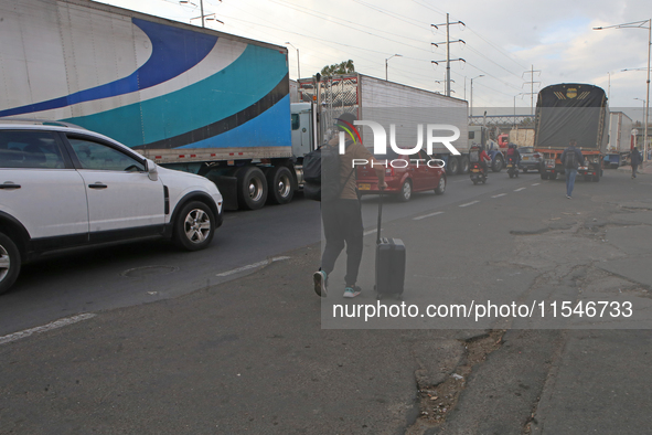 A person walks with a suitcase as truckers block the north of the city in Bogota, Colombia, on September 4, 2024. Truckers mainly protest ag...