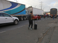 A person walks with a suitcase as truckers block the north of the city in Bogota, Colombia, on September 4, 2024. Truckers mainly protest ag...