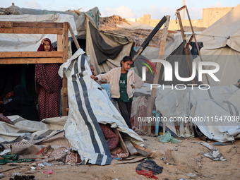 Palestinians inspect the site of an Israeli strike on tents for displaced people inside Al-Aqsa Martyrs Hospital amid the Israel-Hamas confl...