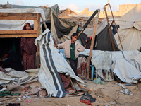 Palestinians inspect the site of an Israeli strike on tents for displaced people inside Al-Aqsa Martyrs Hospital amid the Israel-Hamas confl...