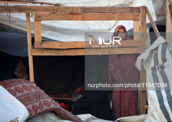 A Palestinian woman inspects the site of an Israeli strike on tents for displaced people inside Al-Aqsa Martyrs Hospital amid the Israel-Ham...