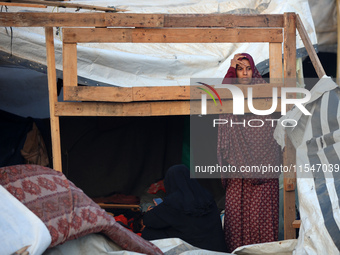 A Palestinian woman inspects the site of an Israeli strike on tents for displaced people inside Al-Aqsa Martyrs Hospital amid the Israel-Ham...