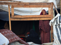 A Palestinian woman inspects the site of an Israeli strike on tents for displaced people inside Al-Aqsa Martyrs Hospital amid the Israel-Ham...