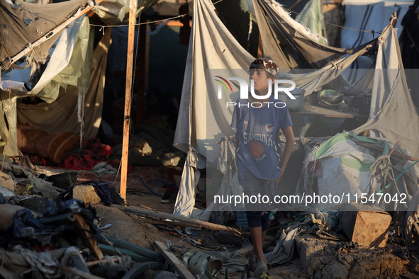 A Palestinian boy inspects the site of an Israeli strike on tents for displaced people inside Al-Aqsa Martyrs Hospital amid the Israel-Hamas...