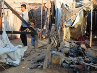 Palestinians inspect the site of an Israeli strike on tents for displaced people inside Al-Aqsa Martyrs Hospital amid the Israel-Hamas confl...