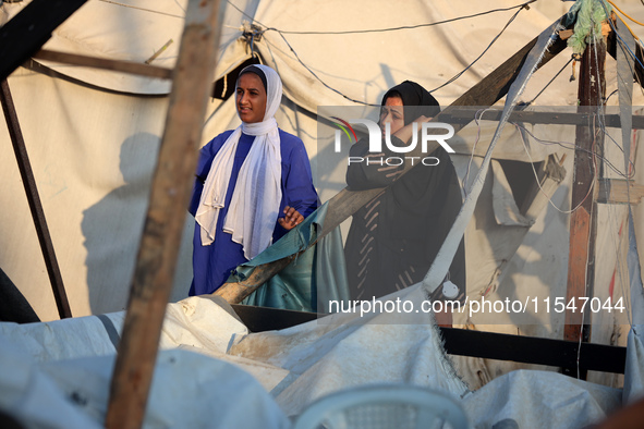 Palestinians inspect the site of an Israeli strike on tents for displaced people inside Al-Aqsa Martyrs Hospital amid the Israel-Hamas confl...