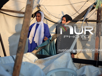 Palestinians inspect the site of an Israeli strike on tents for displaced people inside Al-Aqsa Martyrs Hospital amid the Israel-Hamas confl...