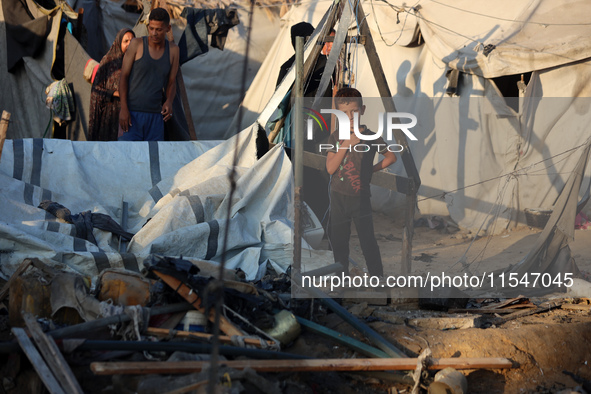 Palestinians inspect the site of an Israeli strike on tents for displaced people inside Al-Aqsa Martyrs Hospital amid the Israel-Hamas confl...