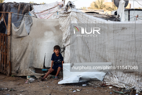 A Palestinian boy inspects the site of an Israeli strike on tents for displaced people inside Al-Aqsa Martyrs Hospital amid the Israel-Hamas...