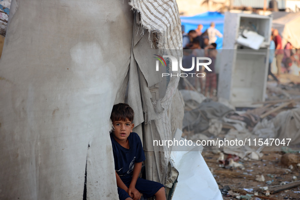 A Palestinian boy inspects the site of an Israeli strike on tents for displaced people inside Al-Aqsa Martyrs Hospital amid the Israel-Hamas...