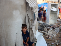 A Palestinian boy inspects the site of an Israeli strike on tents for displaced people inside Al-Aqsa Martyrs Hospital amid the Israel-Hamas...