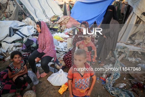 Palestinians inspect the site of an Israeli strike on tents for displaced people inside Al-Aqsa Martyrs Hospital amid the Israel-Hamas confl...