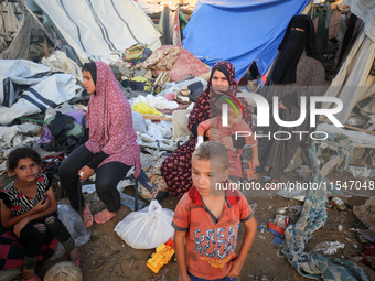 Palestinians inspect the site of an Israeli strike on tents for displaced people inside Al-Aqsa Martyrs Hospital amid the Israel-Hamas confl...