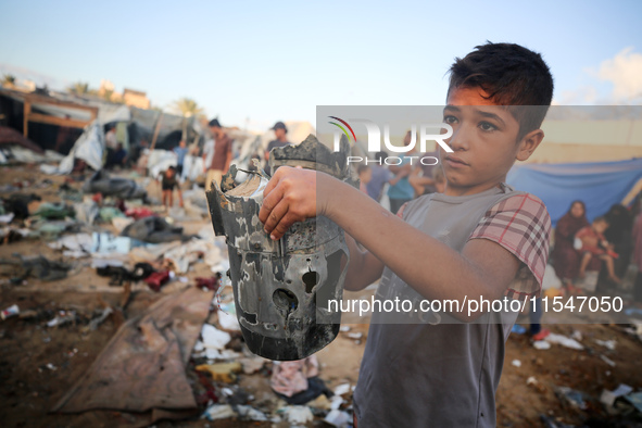 A Palestinian boy inspects the site of an Israeli strike on tents for displaced people inside Al-Aqsa Martyrs Hospital amid the Israel-Hamas...