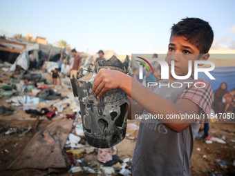 A Palestinian boy inspects the site of an Israeli strike on tents for displaced people inside Al-Aqsa Martyrs Hospital amid the Israel-Hamas...