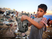 A Palestinian boy inspects the site of an Israeli strike on tents for displaced people inside Al-Aqsa Martyrs Hospital amid the Israel-Hamas...