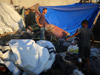 Palestinians inspect the site of an Israeli strike on tents for displaced people inside Al-Aqsa Martyrs Hospital amid the Israel-Hamas confl...