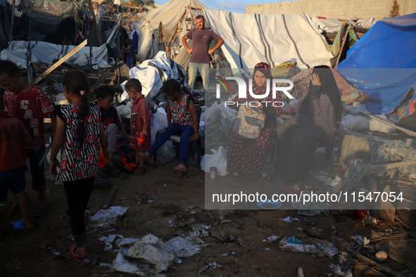 Palestinians inspect the site of an Israeli strike on tents for displaced people inside Al-Aqsa Martyrs Hospital amid the Israel-Hamas confl...