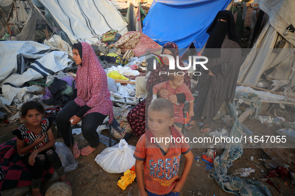 Palestinians inspect the site of an Israeli strike on tents for displaced people inside Al-Aqsa Martyrs Hospital amid the Israel-Hamas confl...