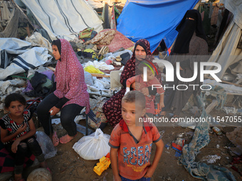 Palestinians inspect the site of an Israeli strike on tents for displaced people inside Al-Aqsa Martyrs Hospital amid the Israel-Hamas confl...