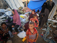 Palestinians inspect the site of an Israeli strike on tents for displaced people inside Al-Aqsa Martyrs Hospital amid the Israel-Hamas confl...