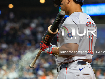 Rafael Devers #11 of the Boston Red Sox sprays his bat with a sticky substance while on deck during the eighth inning of the baseball game a...