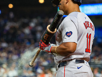 Rafael Devers #11 of the Boston Red Sox sprays his bat with a sticky substance while on deck during the eighth inning of the baseball game a...