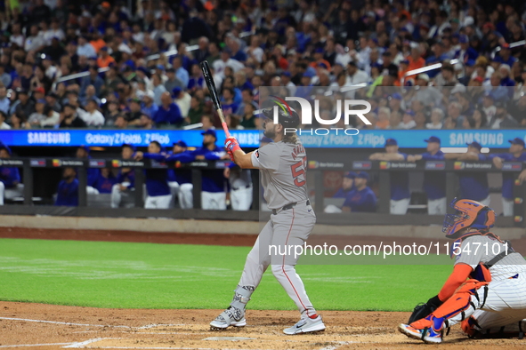 Boston Red Sox Wilyer Abreu #52 hits a sacrifice fly during the third inning of the baseball game against the New York Mets at Citi Field in...