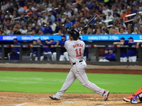 Rafael Devers #11 of the Boston Red Sox hits a sacrifice fly during the third inning of the baseball game against the New York Mets at Citi...