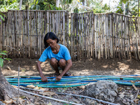 A woman connects a water hose to the only water source to her house during drought season in Selopamioro Village, Bantul Regency, Yogyakarta...