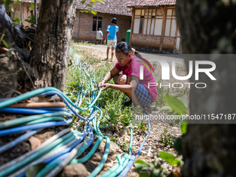 A woman connects a water hose to the only water source to her house during drought season in Selopamioro Village, Bantul Regency, Yogyakarta...