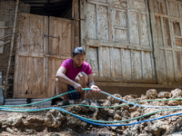 A woman connects a water hose to the only water source to her house during drought season in Selopamioro Village, Bantul Regency, Yogyakarta...