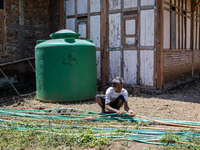 A man connects a water hose to the only water source to his house during drought season in Selopamioro Village, Bantul Regency, Yogyakarta P...