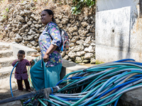 A woman connects a water hose to the only water source to her house during drought season in Selopamioro Village, Bantul Regency, Yogyakarta...