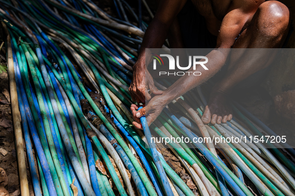 A man connects a water hose to the only water source to his house during drought season in Selopamioro Village, Bantul Regency, Yogyakarta P...