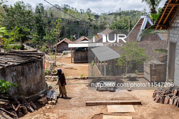 A villager stands near the water source as he waits to collect water during the drought season in Tepus Village, Gunung Kidul Regency, Yogya...