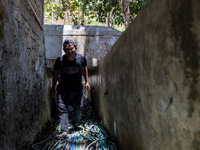 A man walks with a water hose as he directs it to his house during drought season in Selopamioro Village, Bantul Regency, Yogyakarta Provinc...