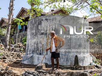 A villager stands near the water source as he waits to collect water during the drought season in Tepus Village, Gunung Kidul Regency, Yogya...