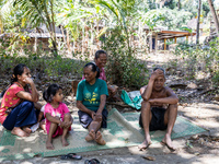 Residents fetch water from the only source by sucking it up and flowing it through a hose to their house during the drought season in Selopa...