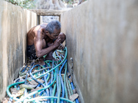 Sarjono (73), an elderly blind man, takes water from the only source of water by sucking it up and flowing it through a hose to his house du...