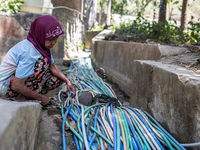 A woman connects a water hose to the only water source to her house during drought season in Selopamioro Village, Bantul Regency, Yogyakarta...