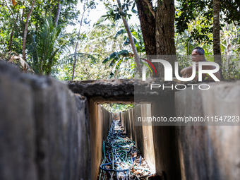 Sarjono (73), an elderly blind man, sits after connecting a water hose to the only water source to his house during the drought season in Se...