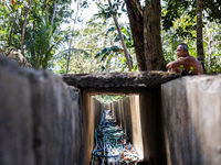 Sarjono (73), an elderly blind man, sits after connecting a water hose to the only water source to his house during the drought season in Se...