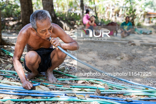 Sarjono (73), an elderly blind man, takes water from the only source of water by sucking it up and flowing it through a hose to his house du...